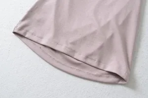 Dusty pink knit top hem detail view, showing fine stitching and soft fabric texture closely.