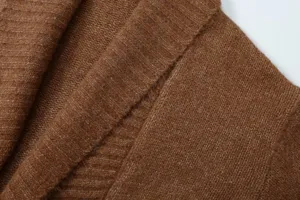 Gros plan sur le col du cardigan en tricot marron, montrant une texture douce et un design côtelé.