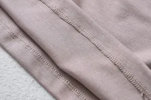 Closeup of the soft ribbed knit fabric texture and fine overlock stitching details.