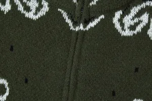 Dark green knit cardigan featuring white jacquard monogram pattern and front zipper detail.