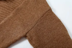 Gros plan détaillé du cardigan en tricot marron montrant une texture fine et une couture d'épaule.