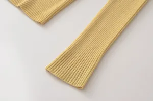 Primer plano de manga de punto acanalado amarillo, textura suave y costuras finas para mujeres.