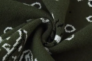 Detailed view of the dark green knitted sweater fabric showcasing soft texture and stylish pattern.