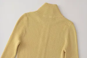 Primer plano detallado de jersey de punto acanalado con cuello alto amarillo de mujer.
