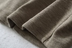Knitted fabric detail close-up showing soft texture and fine stitches. Perfect clothing macro shot.