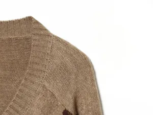 Scatto dettagliato della texture del colletto e della spalla del maglione lavorato a maglia.
