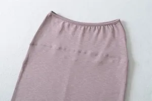 Pink knit bodycon midi skirt detail close-up, showcasing high-waisted ribbed design.