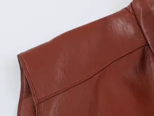 Primo piano dettagliato della spalla del gilet in pelle marrone, con trama fine e cuciture pulite.
