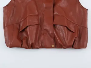 Primo piano del gilet in pelle marrone con tasche con patta e dettaglio orlo arricciato.
