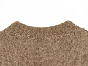 Primo piano dettaglio del colletto rotondo del maglione, tessuto a costine marrone.