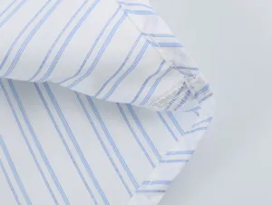 Close-up detail of blue and white striped fabric shirt hem with neat fine stitching.