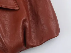 Dettaglio in primo piano del gilet in pelle marrone, che mostra la pregiata texture e le cuciture.