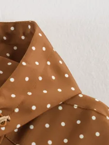 Brown polka dot trench coat collar detail shot showcasing smooth fabric and fine stitching.