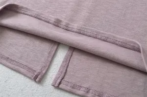 Close-up detail of mauve knit split skirt hem, showcasing fine and neat overlock stitching.