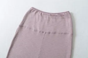 Detailed view of women's dusty pink knit midi skirt with high waist design and clean seam.