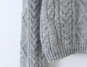 Grijs kabelgebreide trui mouw detail, gezellige winter mode textuur close-up weergave