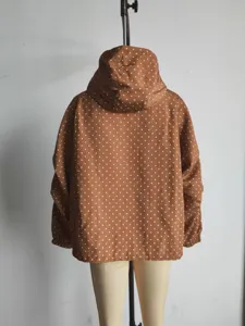 Brown and white polka dot jacket detail, featuring a cozy hood and long sleeves.