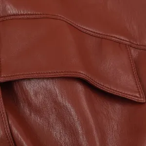Dettaglio gilet in pelle marrone con texture premium e cuciture fini per la moda.