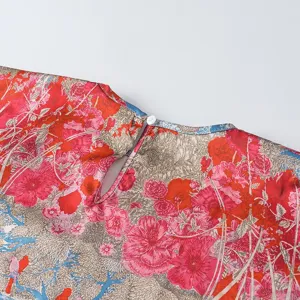 Close-up detail of women's red floral print top showing back button closure and keyhole cut.