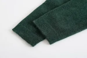 Dark green knit cardigan cuff detail, soft fuzzy texture winter sweater sleeve close up view