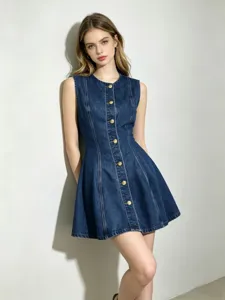 Détail en gros plan de la robe en jean sans manches à boutons dorés et taille cintrée.