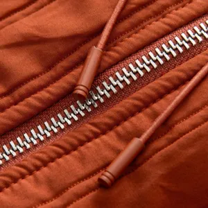 Close-up detail of women's winter coat zipper, metallic teeth and fabric texture display.