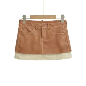 Detail shot of the brown PU leather spliced A-line mini skirt with a beige layered hem.