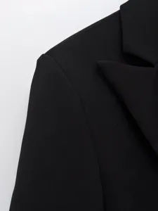Close-up van de schouder en lapel van de zwarte blazer, professionele kantoorstijl.
