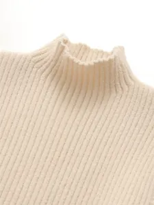 Gros plan sur les details de la texture du col haut en tricot côtelé beige pour femme.