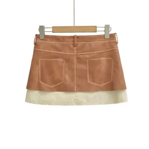 Detailed view of brown faux leather mini skirt featuring back pockets and contrast hem