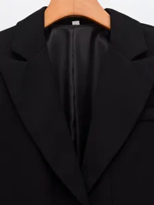 Detailopname van de kraag van een zwarte damesblazer met elegante commuterstijl en gladde voering.