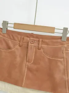 Brown PU leather skirt detail view, showing waistband, button and pocket design, chic style.