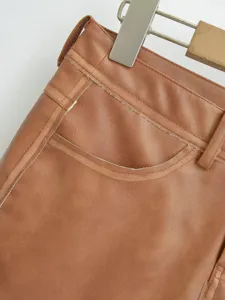 Brown PU leather skirt detail featuring contrast stitching and waist design for women.