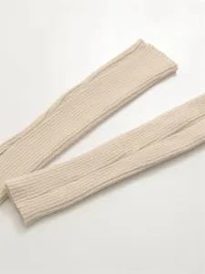 Détail de mancherons en tricot côtelé beige, accessoire en tissu doux et extensible