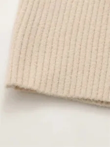 Détail de tissu en tricot côtelé fin de la robe courte élégante pour femme, texture douce.