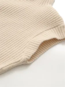 Détail de robe en tricot côtelé beige, col montant élégant tissu élastique pour l'automne.