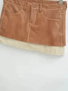 Brown PU leather spliced color-blocking A-line mini skirt, stylish retro streetwear detail.
