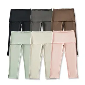 Gedetailleerd overzicht van hoge taille yoga capribroeken met split boorden in kleur.