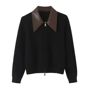 Contrast leather collar detail on black knit cardigan close-up showing exquisite texture and zipper.