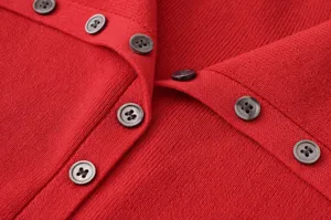 Primer plano que muestra la textura fina del tejido de cárdigan de punto rojo y botones.