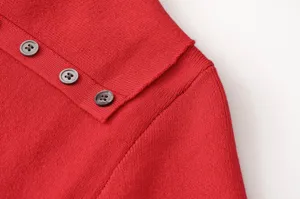 Primer plano detallado del cuello de un cárdigan rojo de punto para mujer con botones.