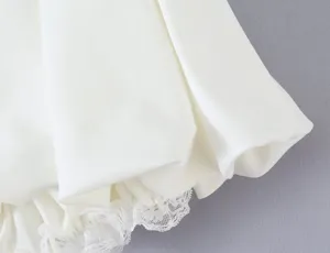 White bubble skirt hem detail shot, featuring smooth fabric and delicate lace trim design.