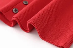 Primer plano detallado del cárdigan de punto rojo con textura de canalé fino y botones.