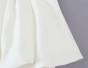White bubble skirt fabric detail, minimalist short skirt close-up view showing smooth texture.