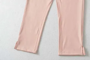 Close-up van roze crop yogabroek met een stijlvolle split aan de onderkant van de zoom.