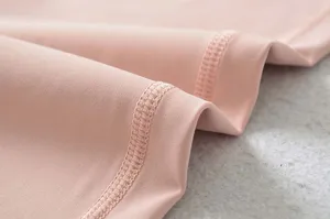 Detailopname van glad roze sporttextiel met fijn stiksel en elastische textuur erin.