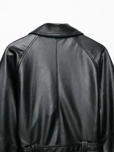 Primo piano del dettaglio posteriore della giacca in ecopelle nera, colletto e maniche raglan.