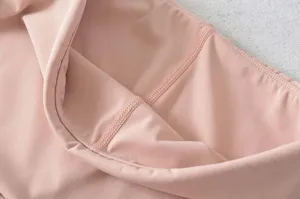 Gedetailleerde close-up toont roze yoga fitness broek stof textuur en fijn stikwerk.