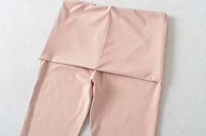 Close-up detail van roze yoga broek met hoge taille en elastische stretch sportstof.