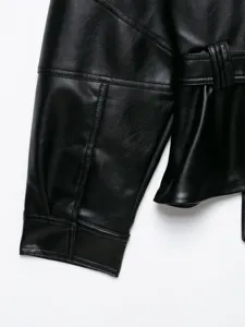 Dettaglio manica e cintura di giacca in ecopelle nera, elegante moda femminile europea.